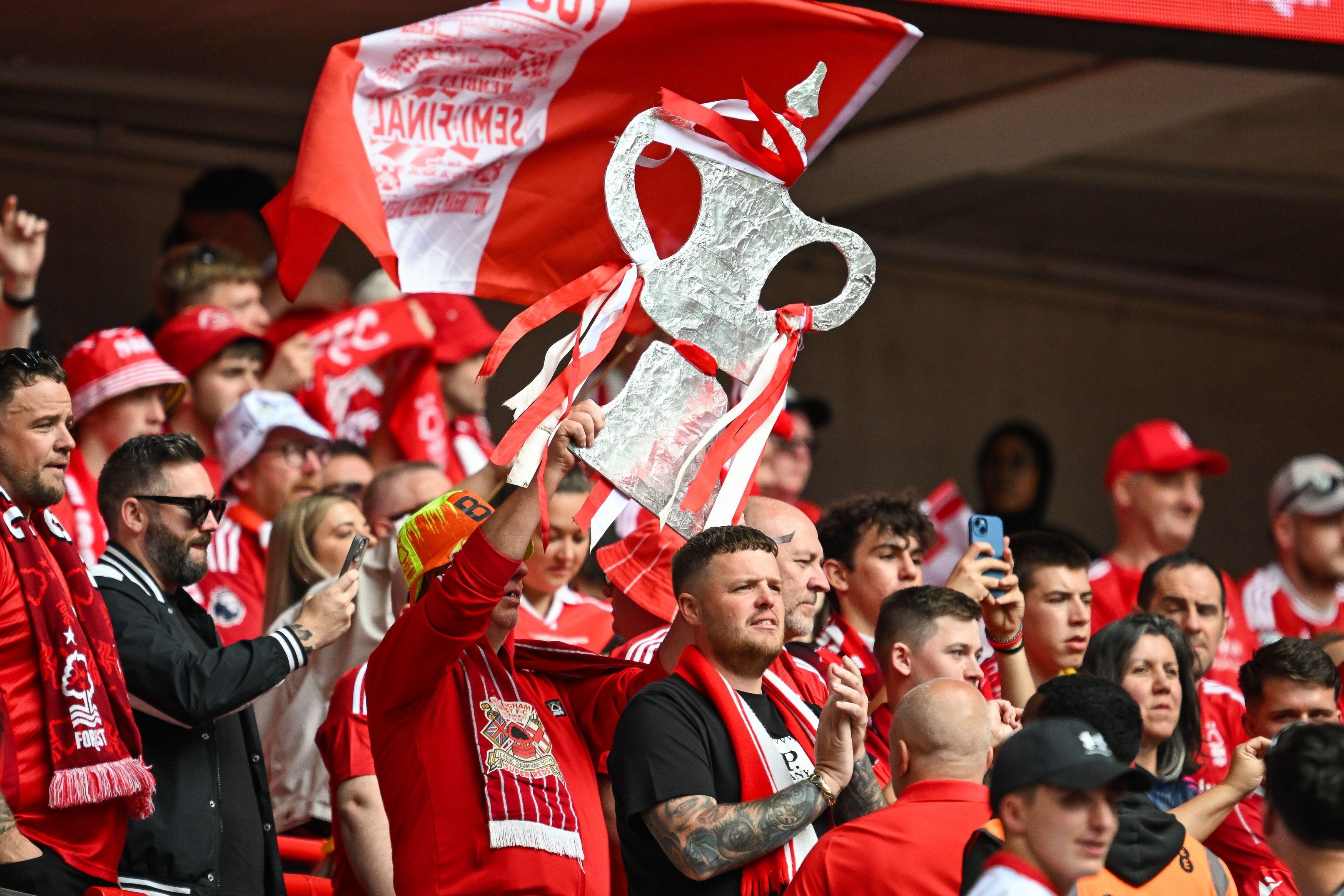 Nottingham Forest fan holding a tin foil FA Cup replica at Wembley Stadium.