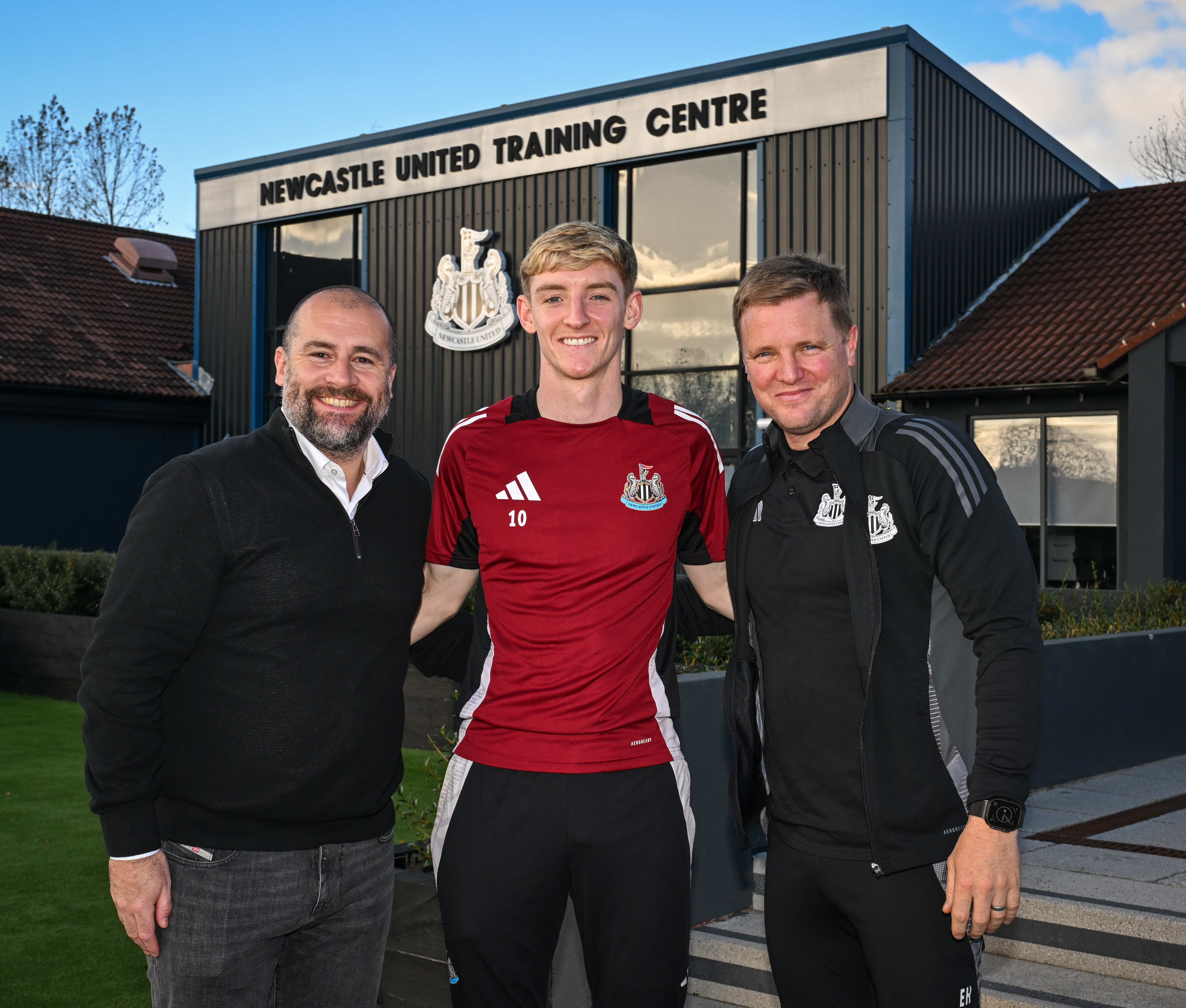 Anthony Gordon of Newcastle United with the Sporting Director and Head Coach after signing a long-term contract.